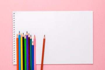 colored colored pencils on the pages of a school notebook