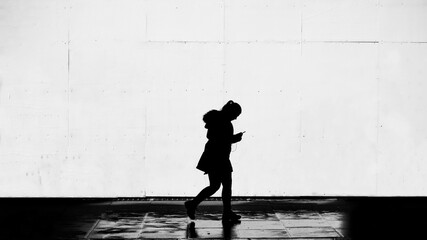 A strolling girl's silhouette in black and white