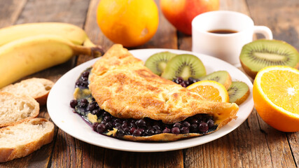 omelette with blueberries, fruit and coffee cup