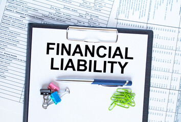 Text Financial Liability on the folder that is located on the financial reports with calculator and...