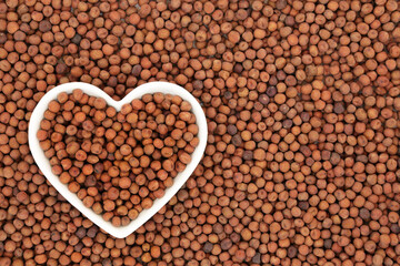 Carlin peas healthy heart food in a white porcelain heart shaped dish & forming an abstract background. Very high in protein, low in fat, high in fibre, antioxidants & anthocyanin with low GI. 