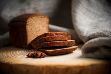 on a wooden table are slices of sliced black bread on a blurry background