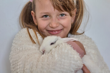 blonde girl with a white rabbit in her arms