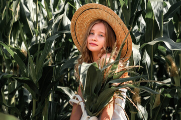 Stylish young girl in vintage clothing and hat posing in a cornfield. Unity with nature. Fashion concept