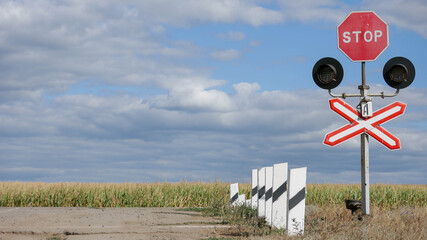 stop sign on a background of blue sky and field
