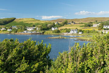 Fototapeta na wymiar Scenic view of Dunvegan village, Isle of Skye, on beautiful sunny summer day. Typical Scottish countryside in Highlands by a sea loch