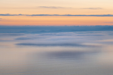 Seascape with low fog clouds over sea water in early morning  sunrise. Beautiful nature background