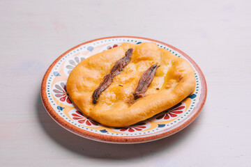 Freshly baked mini pizza сoca with anchovy and oil. Traditional Spanish pastry with vegetables.