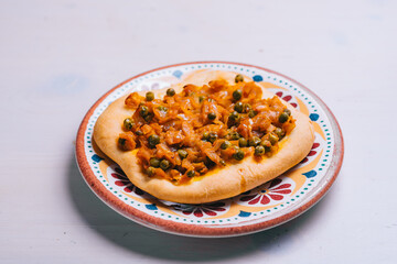 Freshly baked mini pizza сoca with with peas and carrots and onions. Traditional Spanish pastry with vegetables.