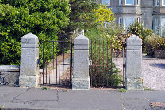 Stone Gate Posts & Iron Gates beside Deserted Pavement 