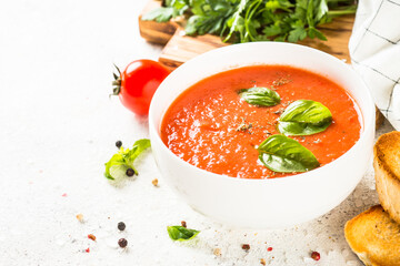 Tomato soup at white table.