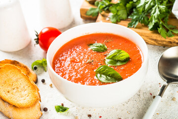Tomato soup at white table.
