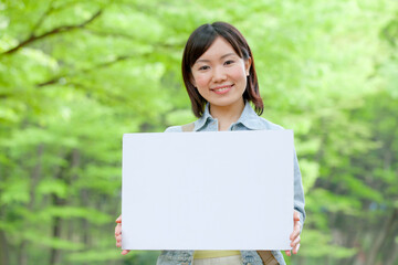 メッセージボードを持つ大学生