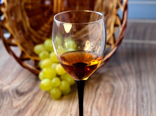 Wine glass with grapes on a wooden background.