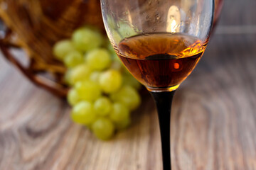 Wine glass with grapes on a wooden background.