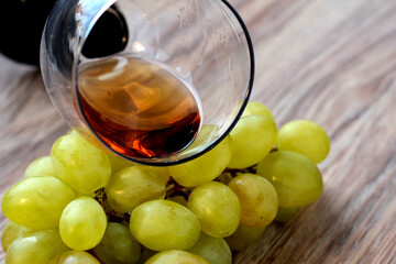 Wine glass with grapes on a wooden background.