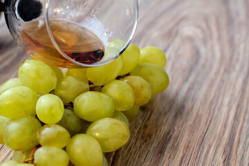 Wine glass with grapes on a wooden background.