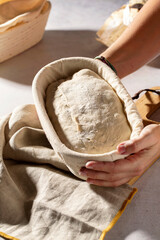 Still life with hands holding a banetone with sourdough