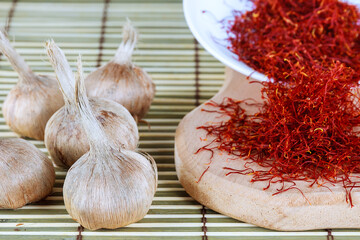 Bulbs of crocus sativus, dry spice saffron in wooden board on a wooden background.