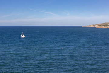 Obraz premium A boat sailing away from the coast