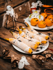Sweet table with fruits and treats for Halloween. Decorations Apple bananas in the form of a mummy with eyes and Ghost. spiders and cockroaches