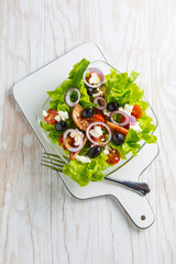 Greek salad with feta cheese, black olives and onion
