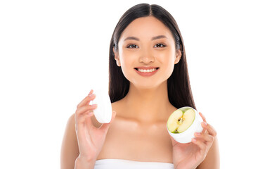 Obraz na płótnie Canvas brunette asian woman holding container of cosmetic cream with half of apple isolated on white