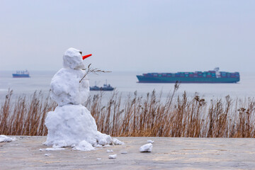 A snowman at the Novosiltsevskaya battery on the Russian island in Vladivostok looks at the ships...