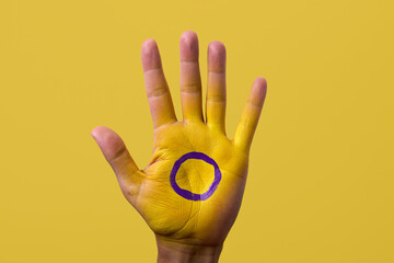 the intersex flag in the palm of the hand