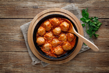 Meatballs in a pan in sweet and sour tomato sauce. Top view.