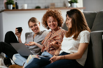 Happy businesswomen talking and laughing in office. Beautiful women drinking coffee in the office.