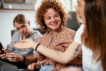 Happy businesswomen talking and laughing in office. Beautiful women drinking coffee in the office.