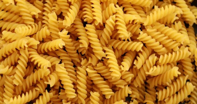 Heap of rotating fusilli pasta on plate closeup