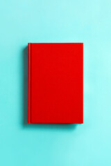 Red book on light blue background.  水色の背景の上の赤い本