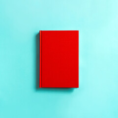 Red book on light blue background.  水色の背景の上の赤い本