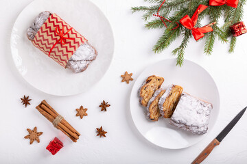 Traditional Christmas stollen cake on white background. Fruit bread with nuts, spices and dried fruit. Top view. Copy space.