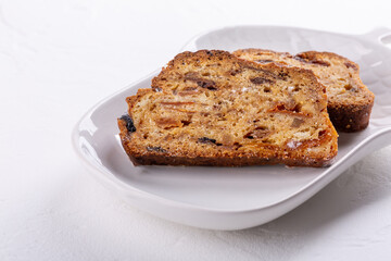 Traditional Christmas stollen cake on white background. Fruit bread with nuts, spices and dried fruit. Copy space.