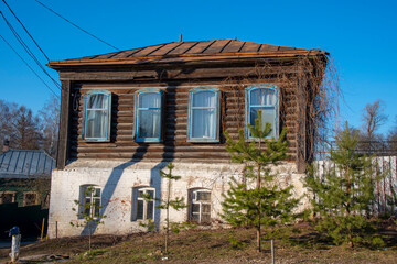 Old two-story house against the bright blue sky.