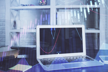 Stock market graph on background with desk and personal computer. Multi exposure. Concept of financial analysis.