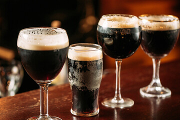 Side view on differend glasses with dark beer