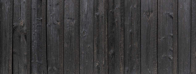 Panorama Detail der alten schwarzen Holzwand einer Scheune aus vertikalen Brettern mit leichten hellen Flusen