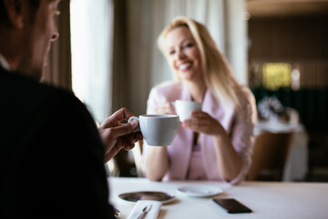 Beautiful businesswoman dressed in the suit drinking coffee. Businesswoman enjoying in the restaurant.