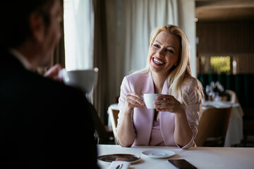 Beautiful businesswoman dressed in the suit drinking coffee. Businesswoman enjoying in the restaurant.
