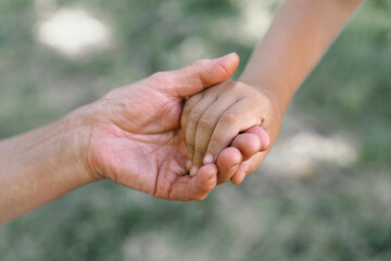 Grandmother and child hold hands. 
