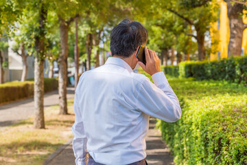マスクを付けた中年男性が屋外で仕事をしている