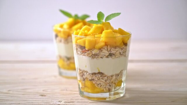 fresh mango yogurt with granola in glass - healthy food style