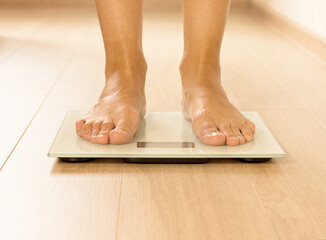 Bare female feet standing on the scales. Healthy lifestyle, food and sport concept