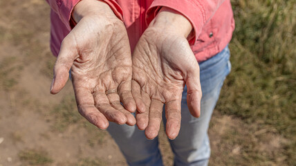 Women's hands are stained with the dust of the earth. Close up