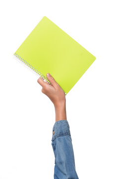 child's hand holding green ring notebook, white background