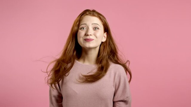 Woman depicts amazement, shows WOW delight face effect. Surprised excited happy girl. Pretty female shocked model on pink background.
